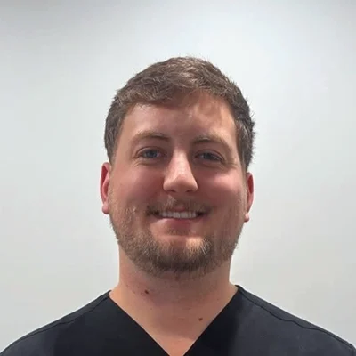 Chiropractor Riley Sadler Smiling In Black Scrubs